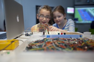 Thinkspace promotional images. Children playing in small groups with technology, gadgets and tutors.